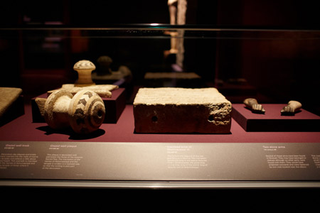 (left to right) Decorative glazed wall knob and plaque, inscribed brick of Shalmaneser III, and two stone arms from the seventh century BC