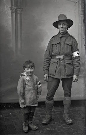 An unidentified member of the Australian Field Ambulance with Robert Thuillier, the photographer’s son, dressed in a field ambulance costume, about 1916–18