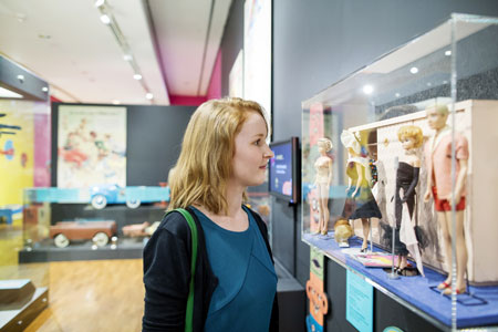 Photograph of a cabinet of Barbie dolls in the 20th-century section of the exhibition