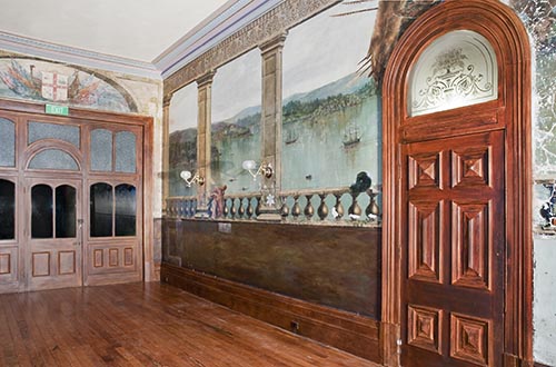 A long view of the Sydney Harbour mural and the over-door leading from the vestibule to the side garden, which is painted with an Australian colonial coat of arms