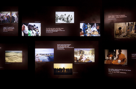 Photograph of the walls inside the exhibition feature backlit photographs of some of the journeys that refugees take to come to New Zealand, with evocative quotes alongside