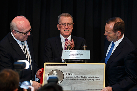 Three people with the plaque